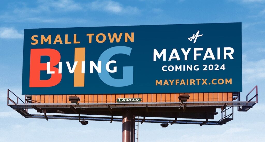 A billboard against a blue sky with the words, "Small Town Big Living. Mayfair Coming 2024. Mayfairtx.com"