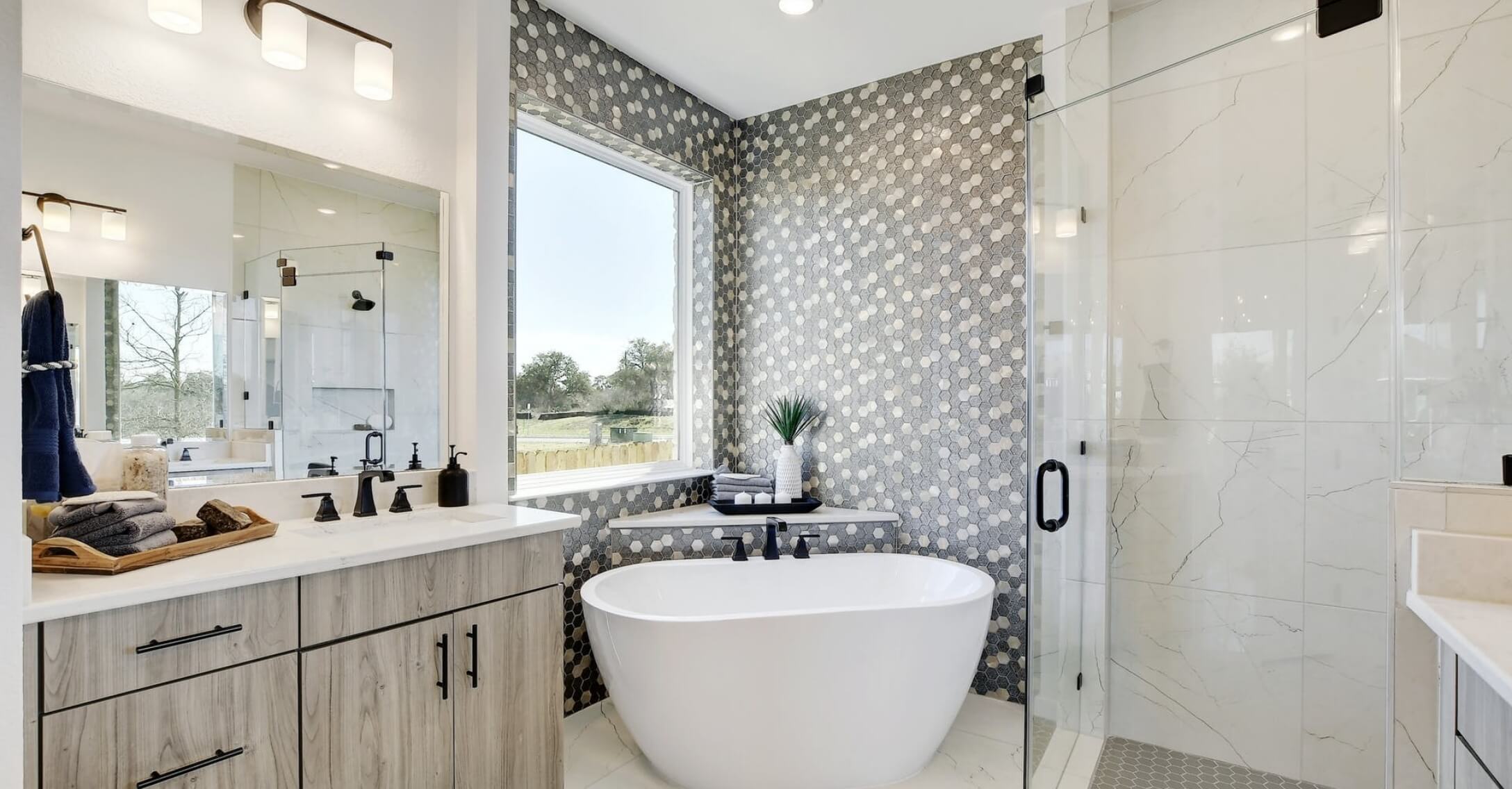 A contemporary bathroom with a spacious tub and walk-in shower in new homes offered by Mayfair Homes in New Braunfels, Texas.