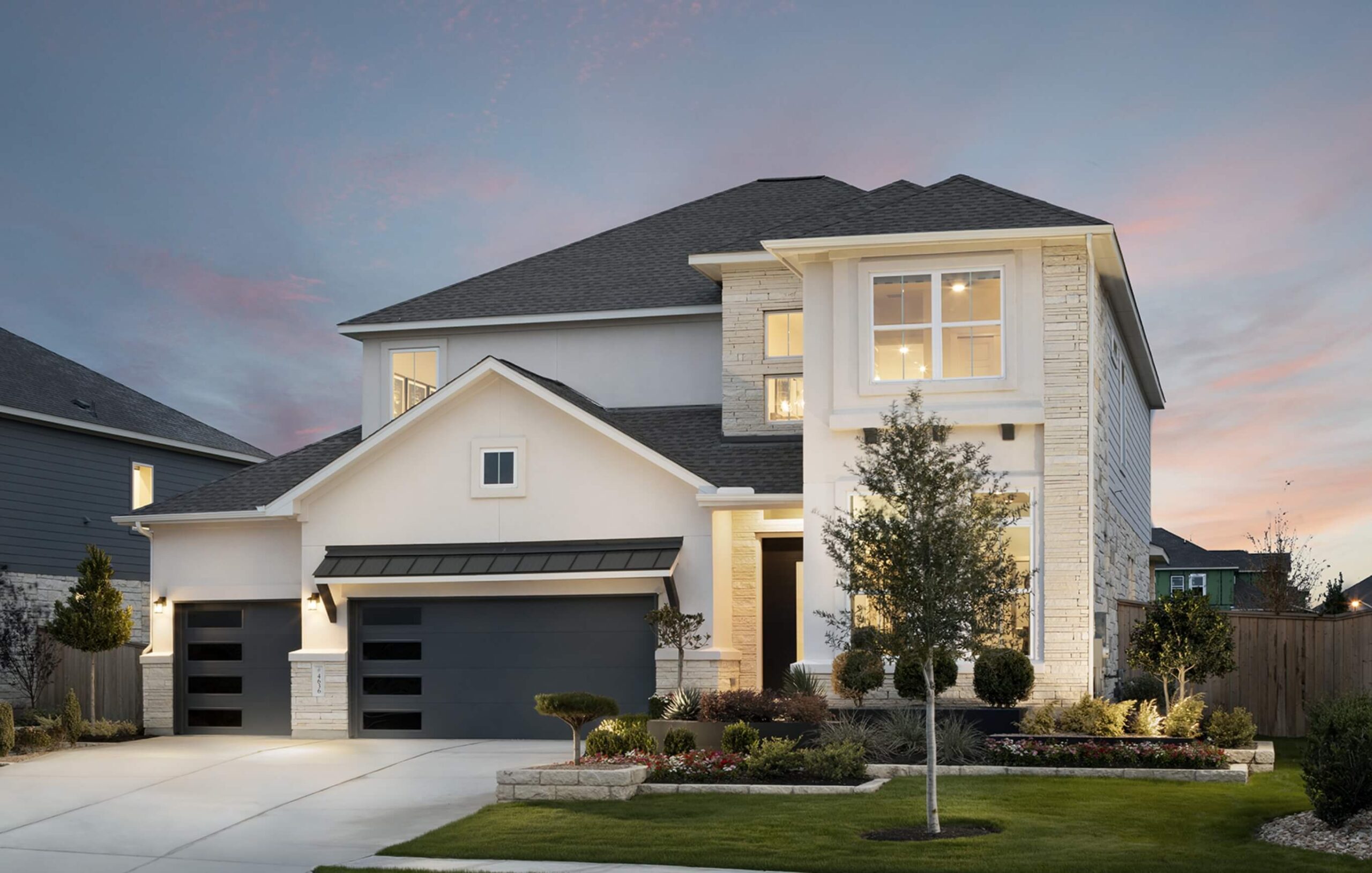 A new home with a garage and driveway in New Braunfels, Texas at dusk.