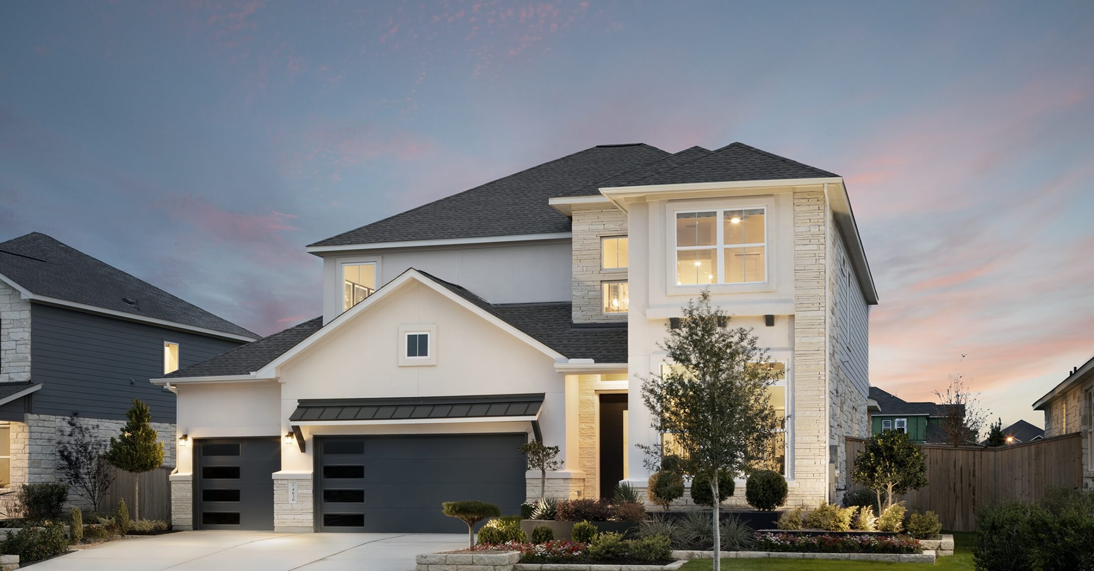 New homes in New Braunfels Texas with a garage and driveway at dusk.