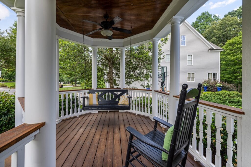 a quaint porch at a bed and breakfast with porch swings