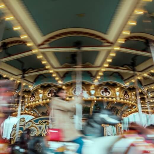 A blurry image of people riding on a carousel at Mayfair homes in New Braunfels, Texas.