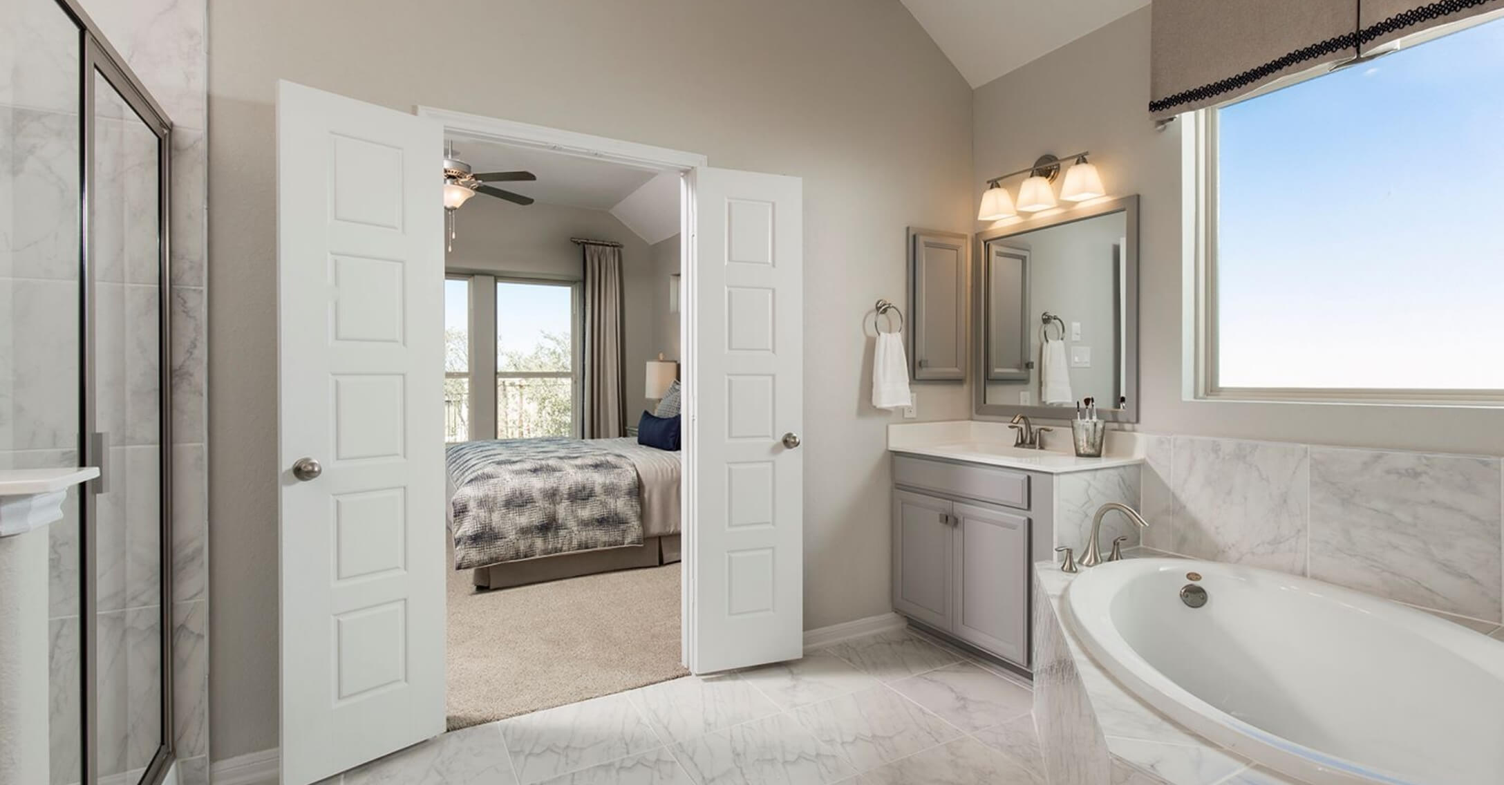 A bathroom with a tub and a walk in shower in Mayfair homes, New Braunfels.