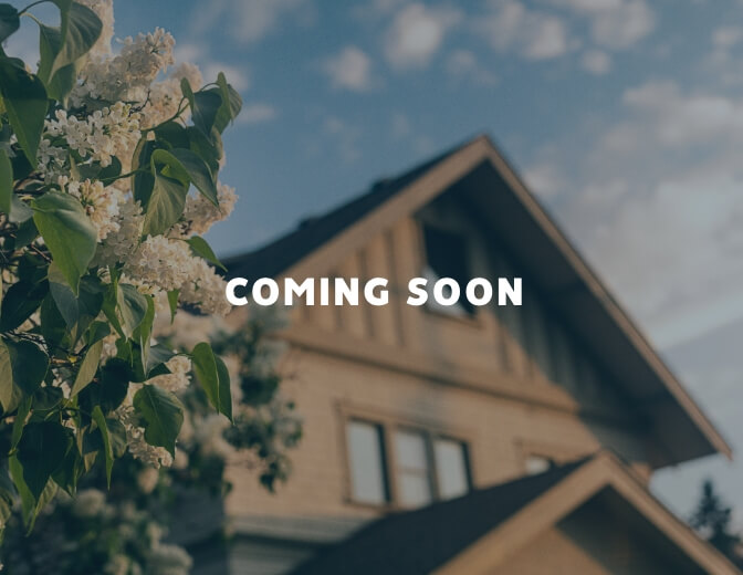 A house with lilacs in front of it, coming soon in Mayfair homes.
