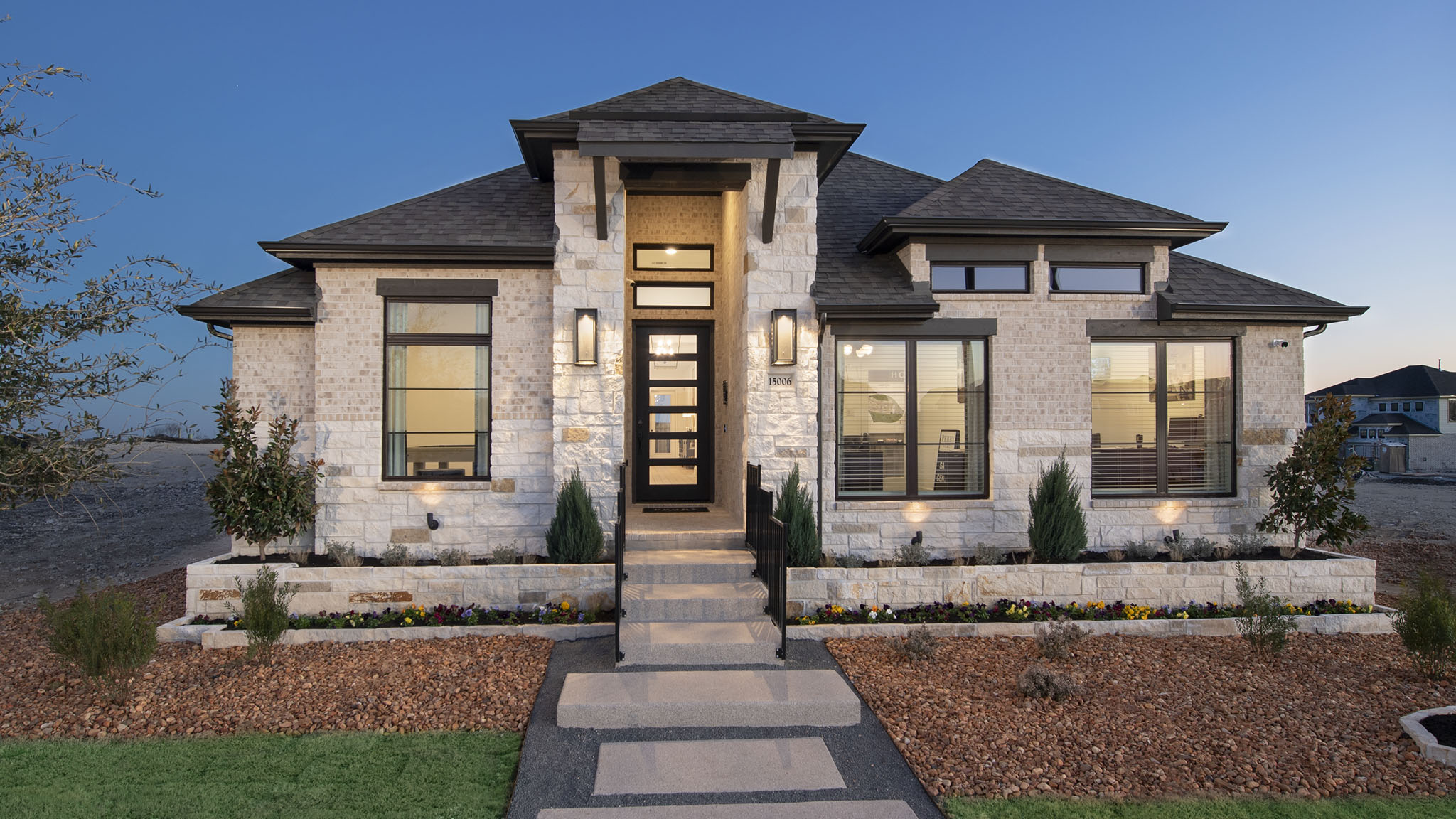 Modern single-story house with stone facade at dusk in New Braunfels.