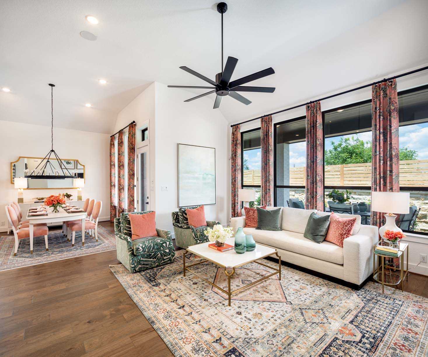 Bright and modern living room in New Braunfels with large windows and an open-plan dining area.